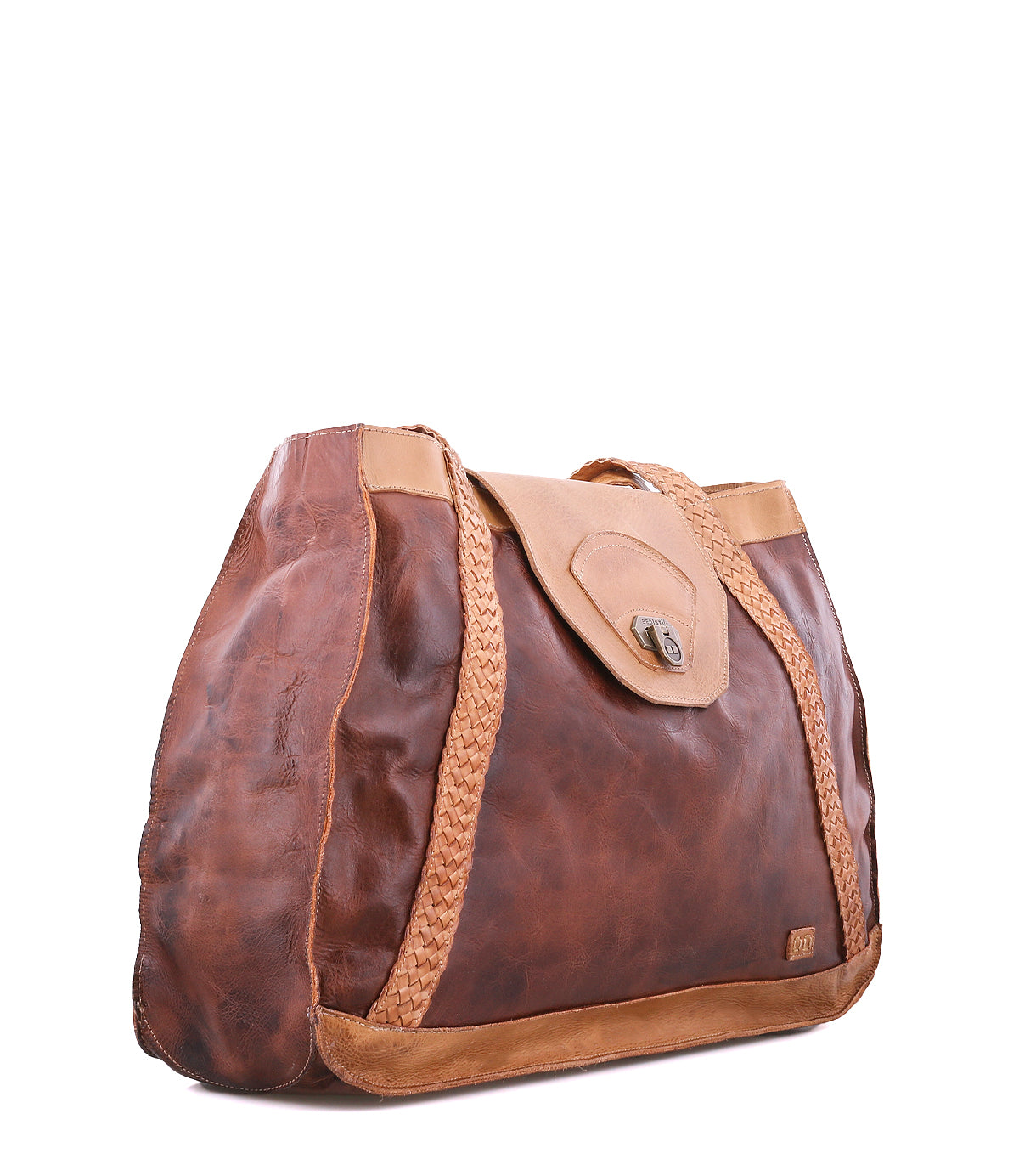The Proper tote bag by Bed|Stü is crafted from brown vegetable-tanned leather with braided accents and handwoven straps, featuring a tan flap closure, visible stitching, and an interior lined with organic cotton. It is displayed against a white background.