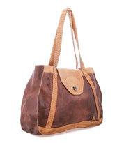 The Proper by Bed|Stü is a brown, vegetable-tanned leather everyday tote with handwoven straps and a flap closure, shown on a white background.