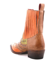 The Bed Stu "Raise" boot features tan and orange leather with a perforated design, vibrant green accents, signature Western stitching, and a stacked heel; viewed from the rear.