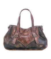Inspired by heritage style, the Redrock by Bed Stu is a compact brown and black distressed leather bag with double handles, buckled straps, and a front "Bed Stu" patch—ideal for daily use.
