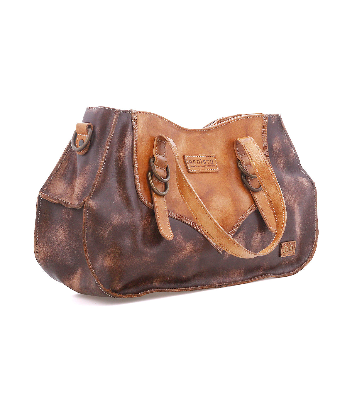 Inspired by heritage style, the Redrock by Bed Stu is a brown and tan leather handbag with double handles, side buckles, and a logo patch—ideal for everyday use.