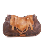 The Bed Stu Redrock is a brown and tan leather handbag with dual handles, a curved flap design, and a front logo patch—heritage-inspired style ideal for everyday use.