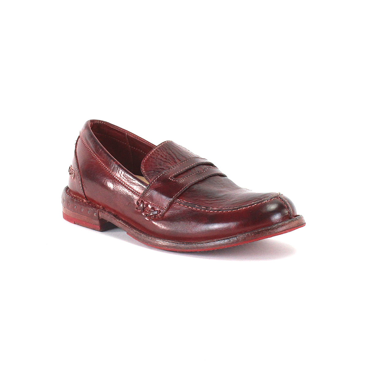A single Reina penny loafer by Bed|Stü in maroon leather is displayed against a plain white background. This timeless design features a smooth leather upper, visible stitching, a low heel, and a slightly worn sole. Classic Goodyear welted construction combines durability with style.