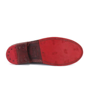The image features the red leather sole of the Bed|Stü Reina penny loafer, highlighting its visible stitching, small nails, and embossed branding details—a testament to the craftsmanship associated with Goodyear welted leather loafers.