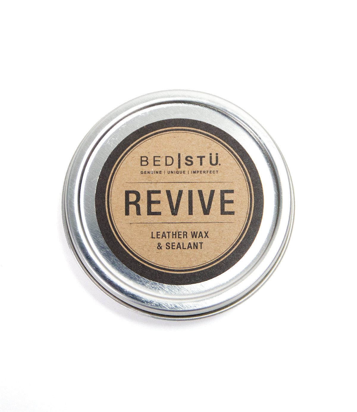 A round tin of Bed|Stü Revive Leather Care Package, labeled in black and gold on a white background.