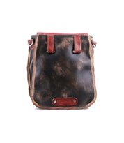 The Bed Stu Rhyme is a small, distressed black leather crossbody bag featuring brown accents and a front leather label, designed for hands-free use. Shown on a white background.