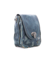 The Bed Stu Rhyme is a blue leather crossbody bag featuring a front flap with metal clasp, visible stitching, and slightly distressed edges—an effortlessly stylish, hands-free accessory for everyday wear.
