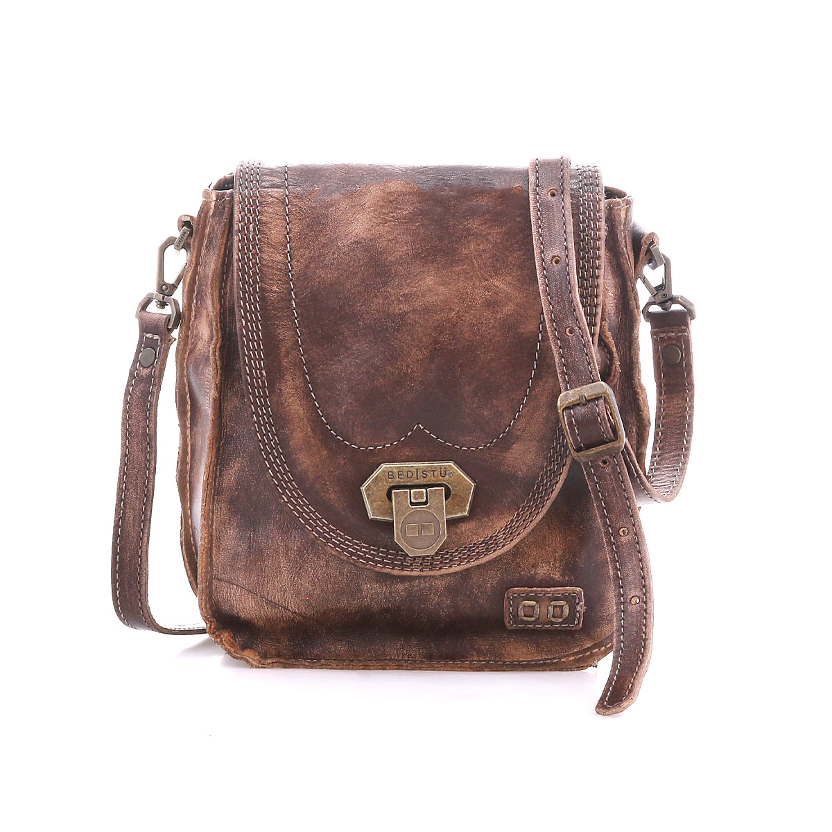 The Bed Stu Rhyme is a compact brown leather crossbody bag with a front flap, brass clasp, adjustable strap, and visible stitching—shown against a white background.