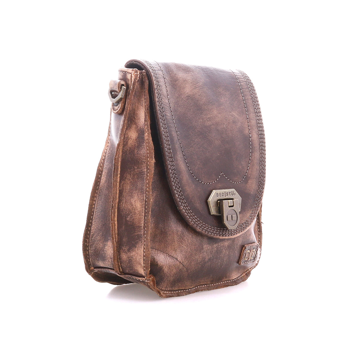 The Bed Stu Rhyme is a brown leather handbag with a distressed finish, front flap, metal clasp, and adjustable strap, shown on a white background.