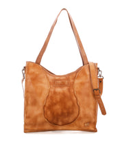 Introducing the Ridgefield by Bed|Stü—a tan full-grain leather shoulder bag featuring two handles, distinctive buckle detailing on the strap, and a front patch adorned with visible stitching and the Bed|Stü logo. Thoughtfully designed as your ideal daily tote, it boasts an organized interior to keep all your essentials neatly arranged.