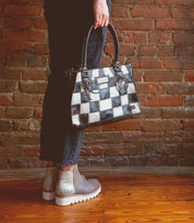 A woman holding a Bed Stu Rockababy SL upcycled leather purse.