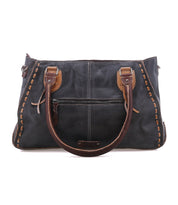The Rockababy by Bed|Stü is a handcrafted handbag in dark vegetable-tanned leather with brown stitching, designed with dual top handles and an exterior zip pocket, and is displayed on a white background.