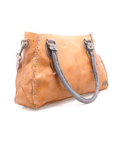 The Bed Stu Rockababy is a tan leather handbag with gray handles, decorative stitching, and a detachable crossbody strap—an ideal compact everyday bag, shown on a white background.