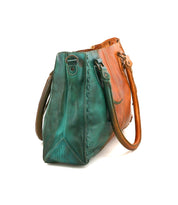 The Rockababy by Bed Stu is a compact leather bag with teal and tan sides, two handles, stylish stitching, and a convenient crossbody strap for versatile everyday use.