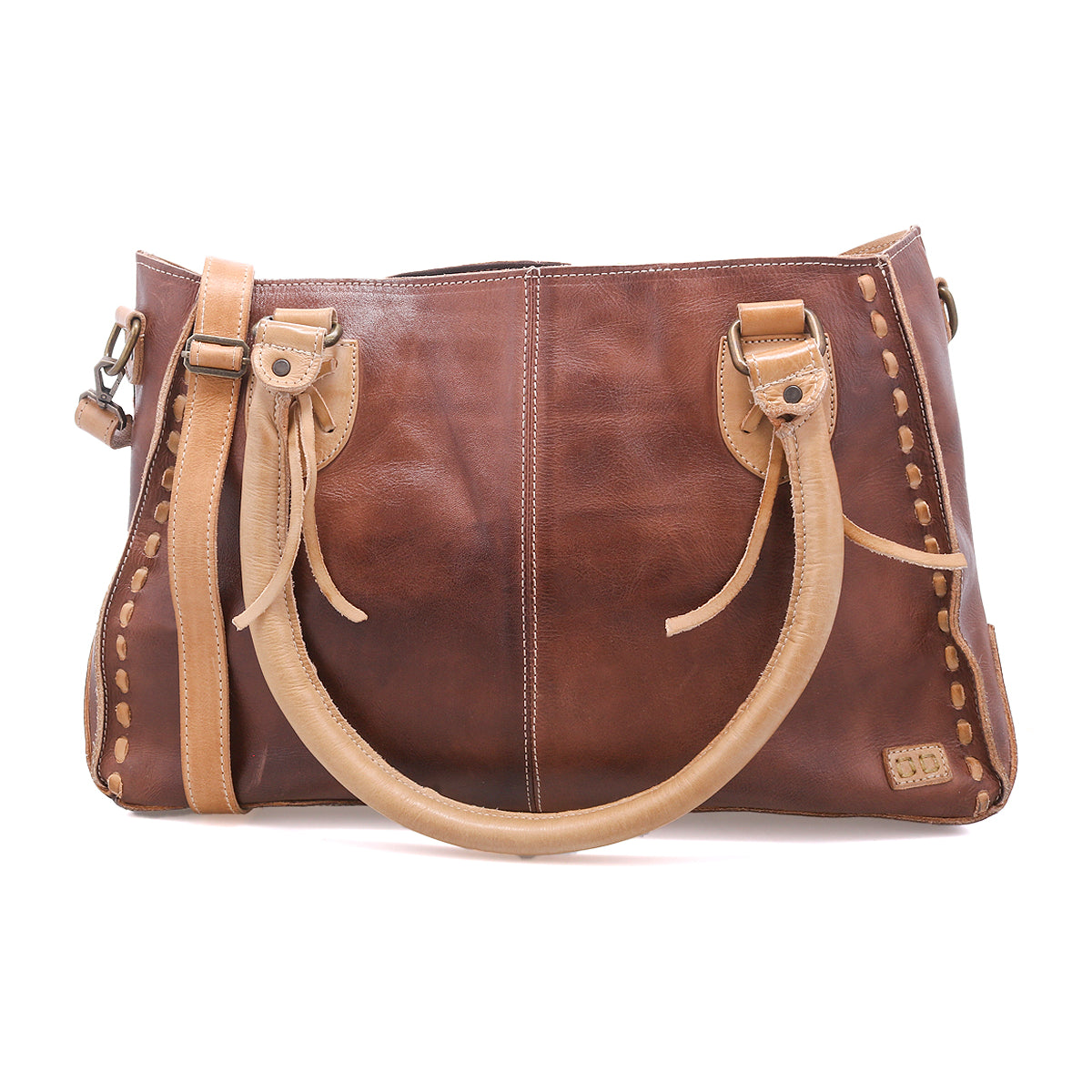 The Bed Stu Rockababy is a handcrafted brown full-grain leather handbag with tan handles, decorative stitching, a shoulder strap, and side details, shown on a white background.