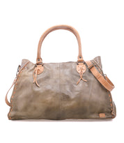 The Bed Stu Rockaway is a large, distressed brown full-grain leather handbag featuring double handles, side stitching, an adjustable shoulder strap, and a convenient zip-pocket divider.