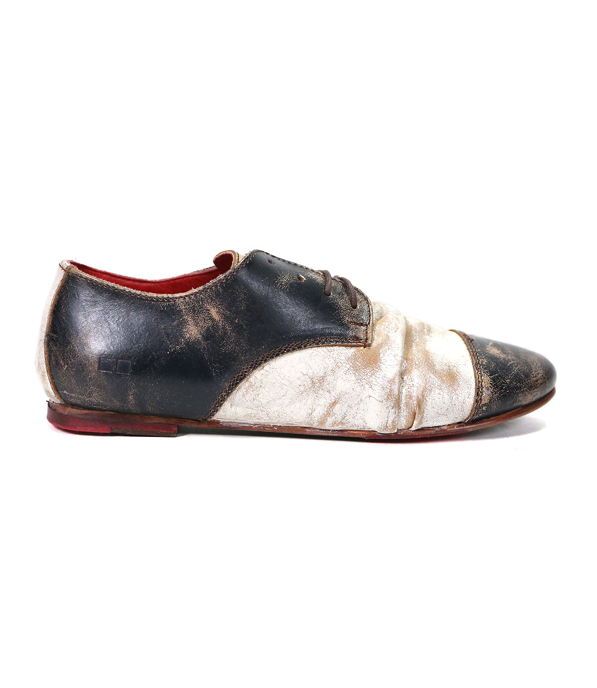 Single worn-out Bed Stu Rumba II black and white leather shoe with red interior, 1920s wingtip design, isolated on a white background.