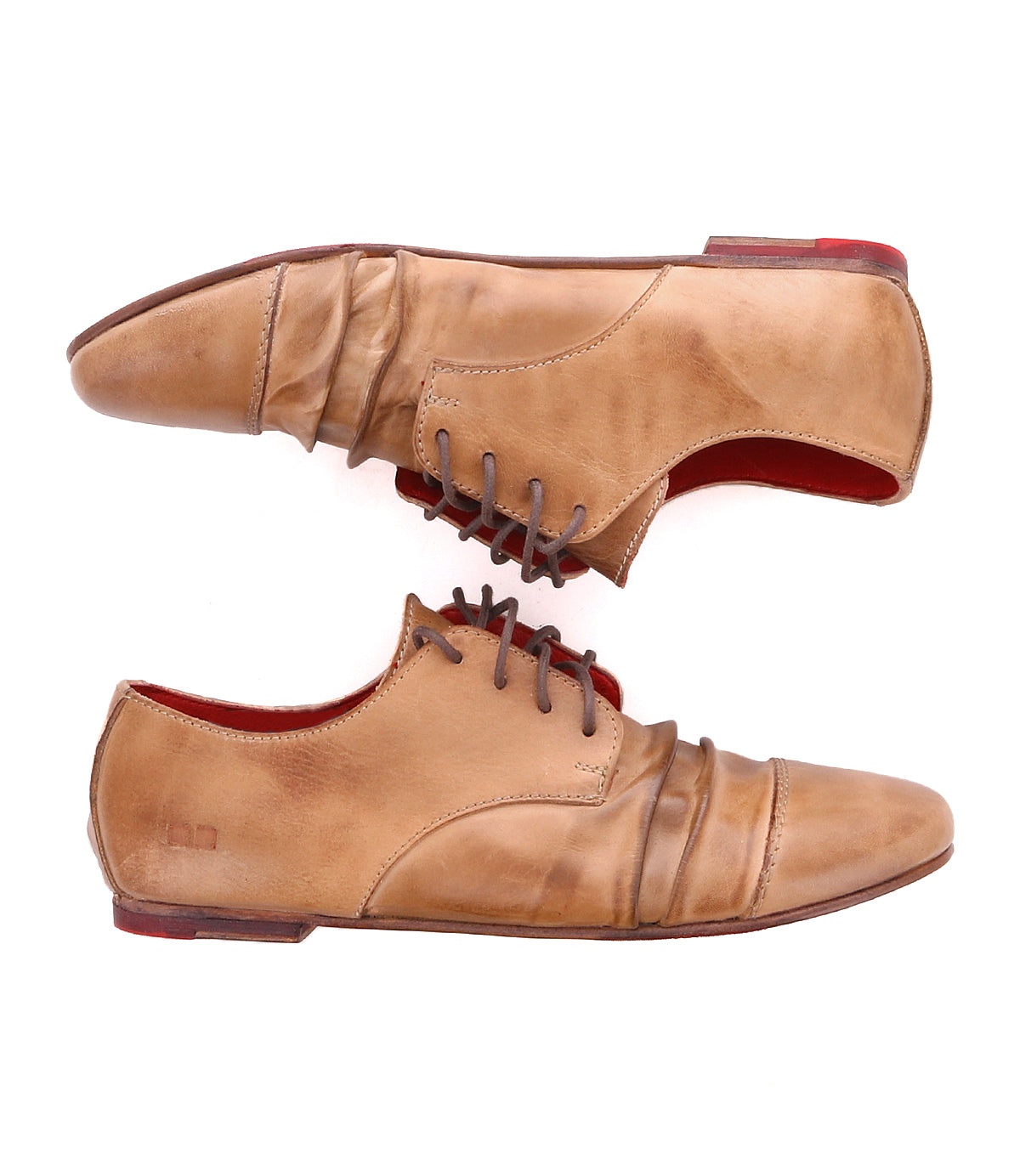 A pair of tan leather dress shoes with red soles and lace-up closures, crafted from buttery soft leather, shown from the side and top views. The Rumba II by Bed Stu.