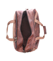 The Bed Stu Ruslan is a brown leather duffle bag with durable canvas straps and beige handles, shown with its main compartment partially unzipped against a white background.