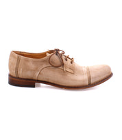A single light brown suede Sandstorm oxford shoe by Bed Stu with a suede upper and a wooden heel, viewed from the side against a white background.
