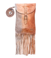 The Bed Stu Sandy Lane II is a handmade crossbody bag in rich brown vegetable-tanned leather, featuring a flap closure, decorative stitching, long bottom fringe, and a detachable strap coiled beside it.