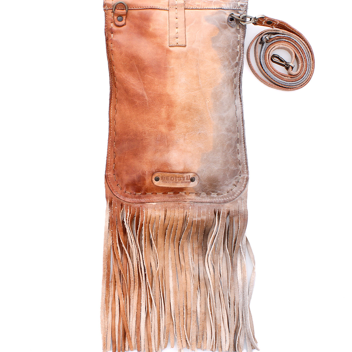 The Bed Stu Sandy Lane II is a tan fringe crossbody bag made from handmade vegetable-tanned leather, featuring a stitched flap, metal hardware, and adjustable strap, shown on a white background.