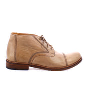 A side view of a beige handcrafted leather dress shoe with brown stitching and a wooden sole. The Bed Stu Scoot, resembling an Italian lace-up boot, features laces and a refined cap toe design.