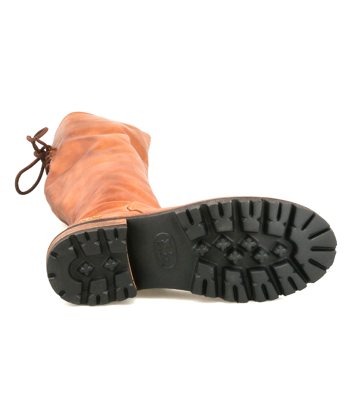 The Bed Stu Scope boot is a tall brown leather women’s style shown sole up, highlighting its black rugged tread pattern for traction.