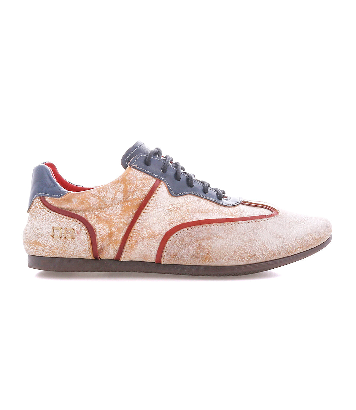 The Bed Stu Scurry II is a beige and orange casual sneaker with a low-profile silhouette, gray laces and sole, red trim, and textured side pattern.