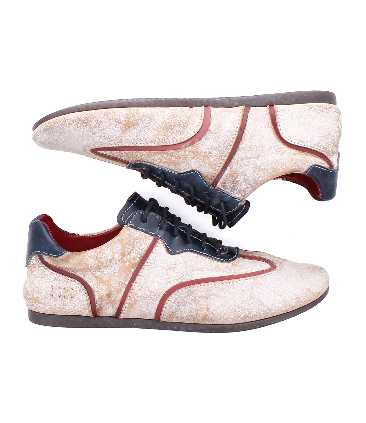 A pair of Bed Stu Scurry II beige casual sneakers with brown soles, black laces, and brown accents, featuring a low-profile design and shown in side view against a white background.