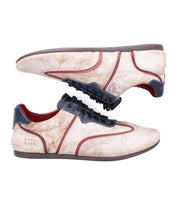 A pair of Bed Stu Scurry II beige casual sneakers with brown soles, black laces, and brown accents, featuring a low-profile design and shown in side view against a white background.