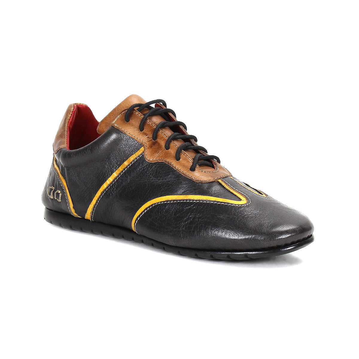 The Bed Stu Scurry is a women’s shoe in black and brown vegetable-tanned leather with yellow accents, black laces, and a flat rubber sole, shown on a white background.