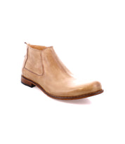 A tan Chelsea boot made from vegetable-tanned leather, featuring a low heel and a sleek design, showcases artisanal craftsmanship. This is the Seek by Bed Stu.