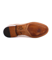 The image shows the sole of a men's brown Chelsea boot, crafted from vegetable-tanned leather with visible wear. The bottom is stamped with text indicating "Made in Italy" and size 45, showcasing artisanal craftsmanship. The boot is the Seek by Bed Stu.