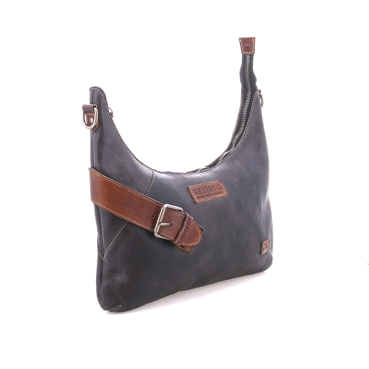 The Bed Stu Seemly is a black leather shoulder bag with a brown strap, buckle accents, zippered top, and patch label—ideal as a compact, everyday accessory.