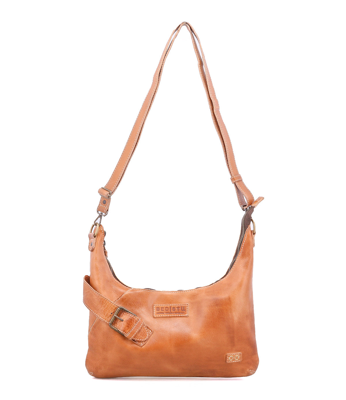 The Bed Stu Seemly is a compact tan leather shoulder bag featuring an adjustable strap, decorative buckle, and a front logo patch—ideal for everyday style.