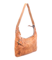 The Seemly by Bed Stu is a light brown leather shoulder bag featuring a single strap, side buckle detail, zipper closure, and embossed front branding—a compact choice for everyday style.