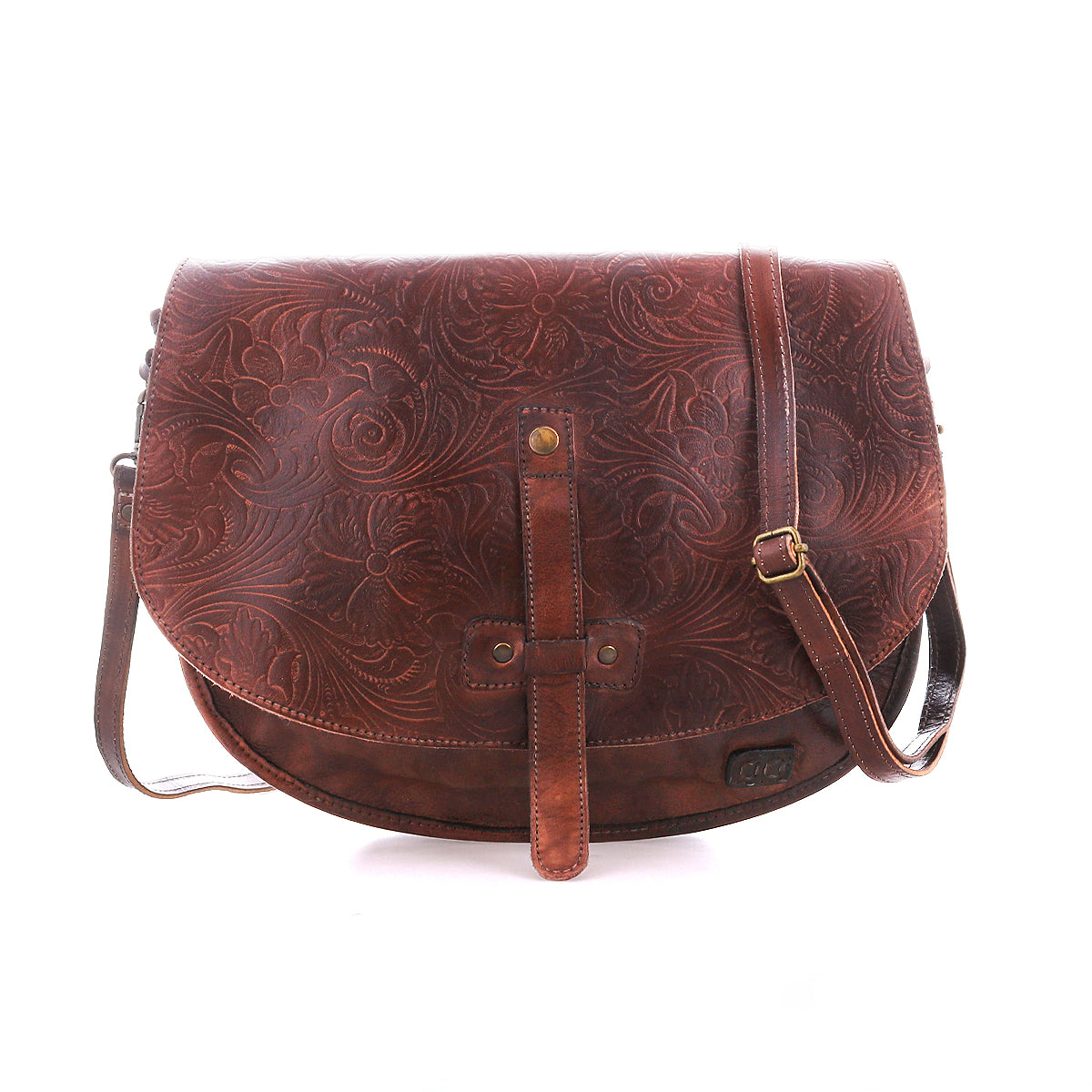 The Bed Stu Sequoia EM is a brown vegetable-tanned leather crossbody saddle bag with an embossed floral pattern, front flap closure, and adjustable strap, shown against a white background.