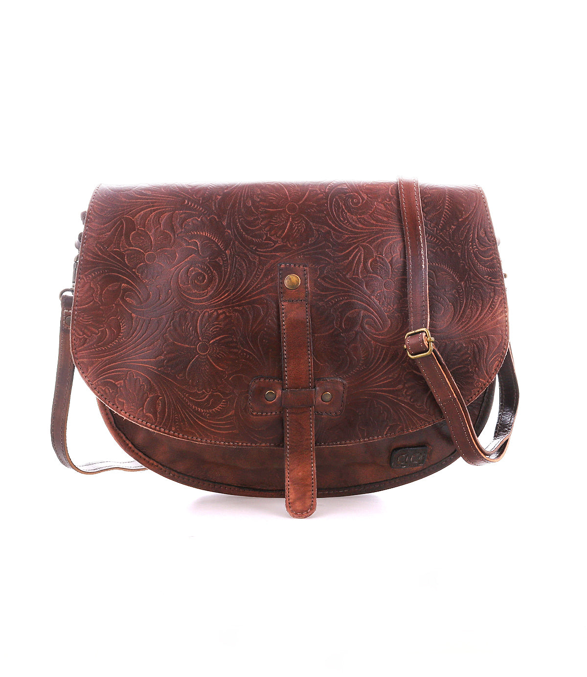 The Bed Stu Sequoia EM is a brown vegetable-tanned leather crossbody saddle bag with an embossed floral pattern, front flap closure, and adjustable strap, shown against a white background.