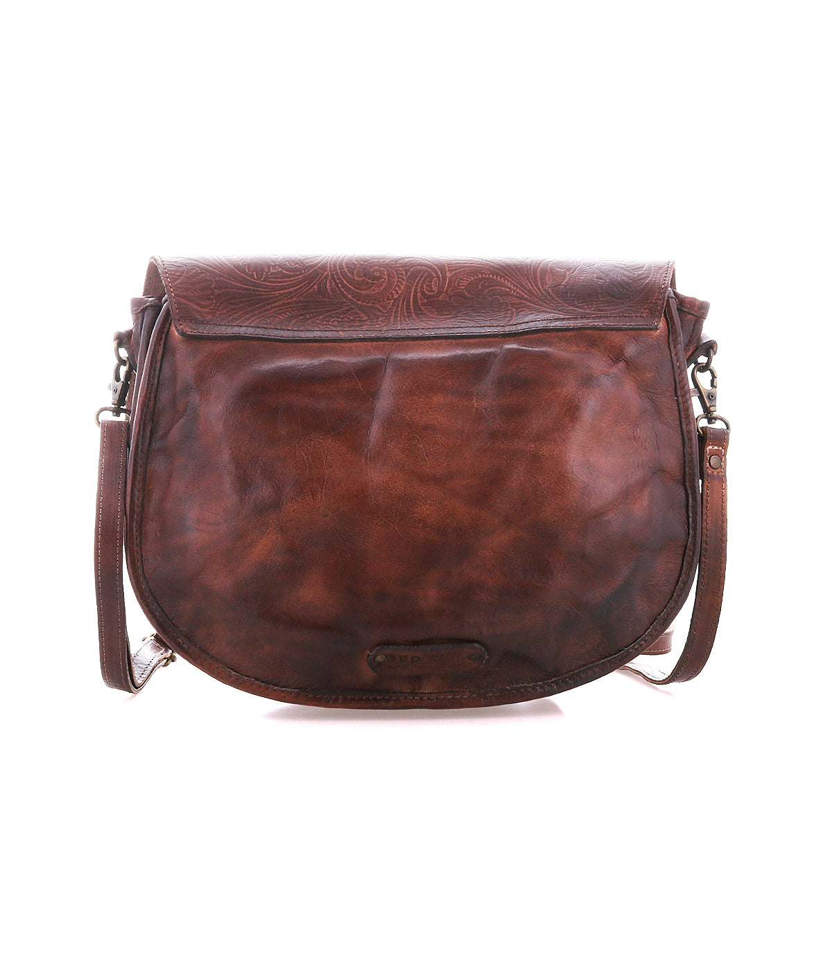 The Bed Stu Sequoia EM is a brown vegetable-tanned leather crossbody saddle bag with embossed flap detailing, a front flap closure, and an adjustable strap, shown against a white background.