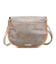 The Bed Stu Sequoia is a gray vegetable-tanned leather crossbody bag with a flap closure, long adjustable strap, and a small beige logo patch at the front bottom center.