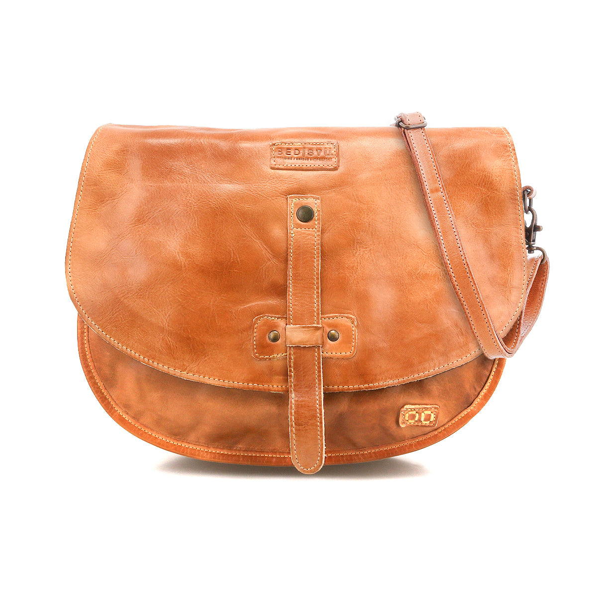 The Bed Stu Sequoia is a light brown vegetable-tanned leather crossbody bag featuring a front flap, buckle strap detail, and adjustable shoulder strap, shown against a white background.