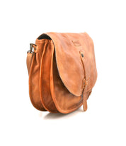 The Bed Stu Sequoia is a brown crossbody bag made from vegetable-tanned leather, with a flap closure, front buckle strap, and adjustable shoulder strap, displayed at an angle on a white background.