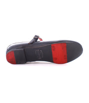 The image shows the underside of a black ballet flat with a red sole and an adjustable metal buckle strap, perfect for embracing the ballerina core trend. This is the Shuffle III by Bed Stu.