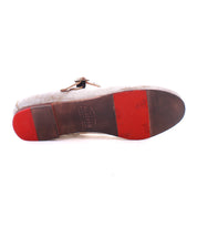 The bottom view of a Shuffle III ballet flat's brown and red sole shoe from Bed Stu, displaying worn-out areas and visible text and logos on the sole, reflects the ballerinacore trend.