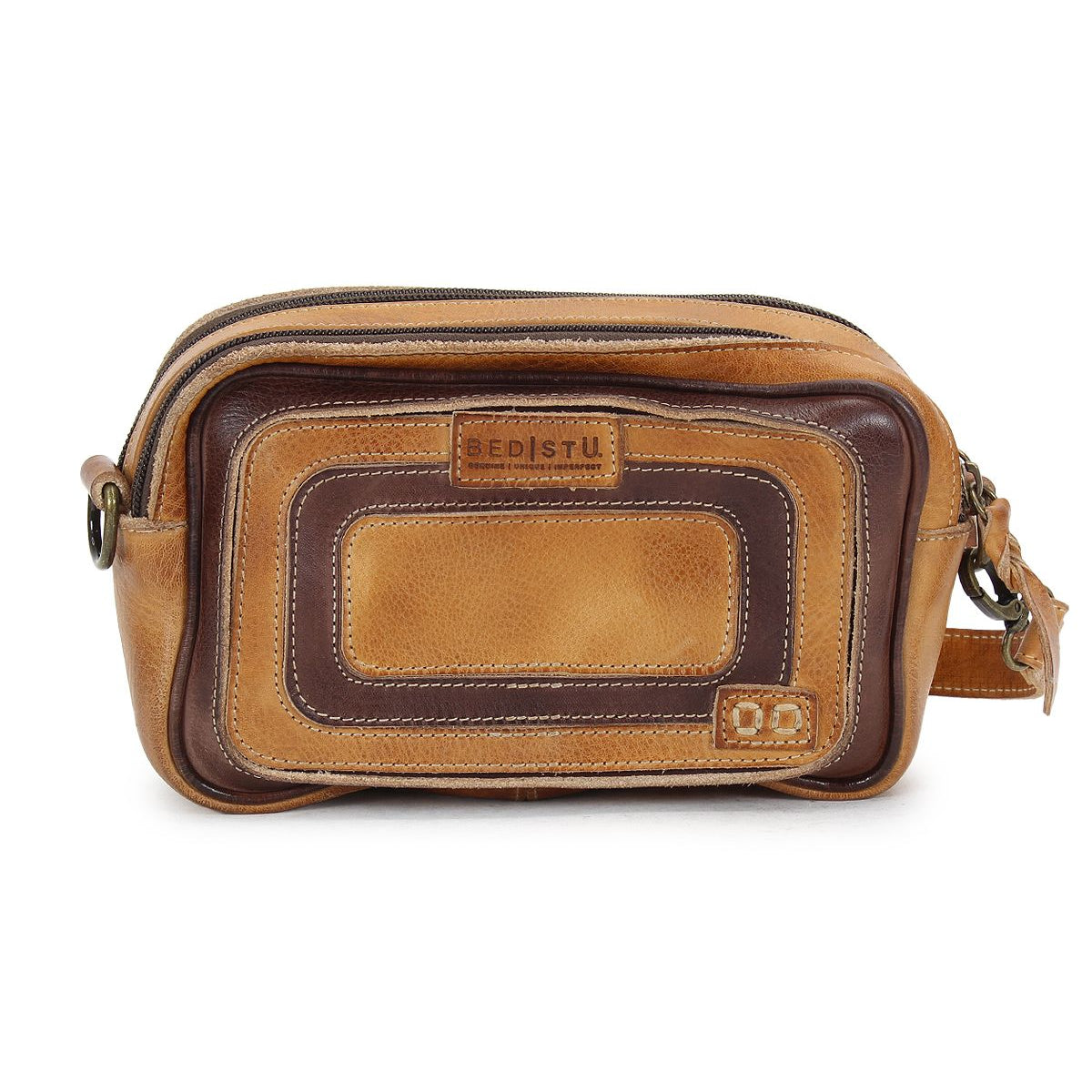 The Shy bag by Bed Stu is a brown leather crossbody featuring dual zippers and a front pocket, with contrasting lighter and darker brown panels for an organized style.