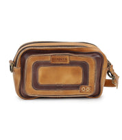 The Shy bag by Bed Stu is a brown leather crossbody featuring dual zippers and a front pocket, with contrasting lighter and darker brown panels for an organized style.