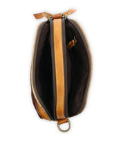 Top view of an open tan leather "Shy" crossbody bag by Bed Stu, showcasing a dark interior with two separate zippered compartments for organizational ease and a metal ring at the bottom.