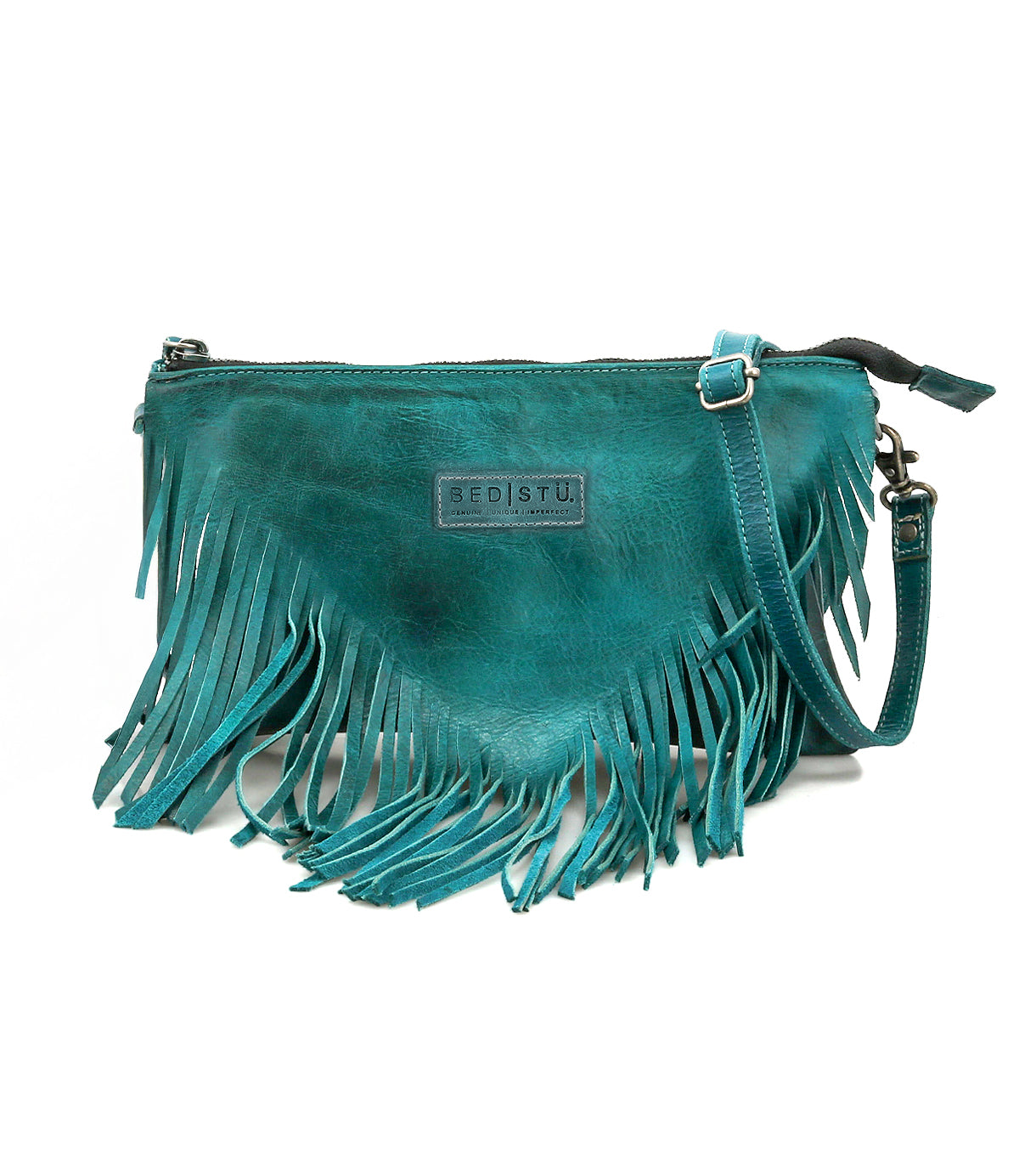 The Bed Stu Silverrock is a teal leather crossbody clutch with fringe detailing, zipper closure, adjustable strap, and a front brand label.