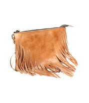 The Bed Stu Silverrock is a light brown crossbody bag featuring long fringe details and a zipper closure, shown against a white background.